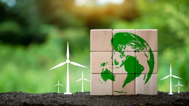 Stacked wooden blocks with globe icon and windmill on nature background. It's a concept to help preserve the environment. Concept of saving the world.