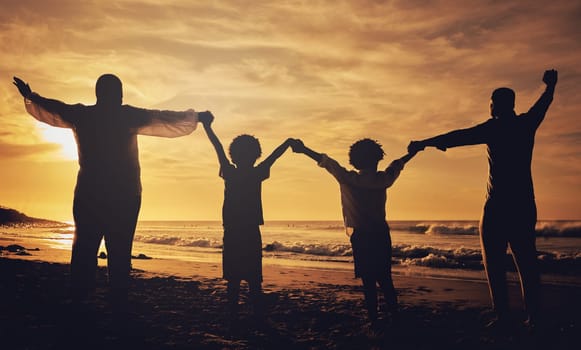 Holding hands, sunset and silhouette of a family at the beach with love, freedom and happiness. Summer, travel and back of parents with children, affection and together in the dark by the ocean.