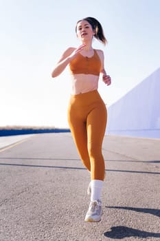 vertical photo with motion of a caucasian sportswoman running in a athletic track, concept of sport and active lifestyle