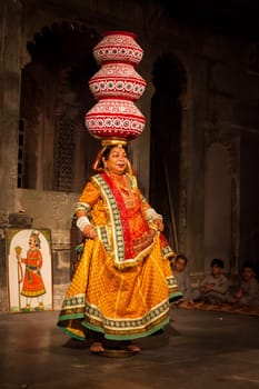 UDAIPUR, INDIA - NOVEMBER 24, 2012: Bhavai - famous folk dance of Rajasthan. Performer balances number pots as she dances on the rim of a brass thali (plate). November 24, 2012 in Udaipur, Rajasthan, India