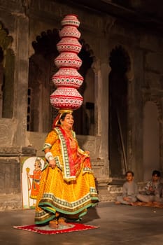 UDAIPUR, INDIA - NOVEMBER 24, 2012: Bhavai performance - famous folk dance of Rajasthan state. Performer balances number of pots as she dances on broken glass. November 24, 2012 in Udaipur, Rajasthan, India