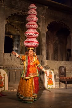 UDAIPUR, INDIA - NOVEMBER 24, 2012: Bhavai performance - famous folk dance of Rajasthan state of India. Performer balances number of earthen pots as she dance. November 24, 2012 in Udaipur, Rajasthan, India