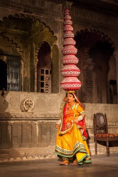 UDAIPUR, INDIA - NOVEMBER 24, 2012: Bhavai performance - famous folk dance of Rajasthan state of India. Performer balances number of earthen pots as she dance. November 24, 2012 in Udaipur, Rajasthan, India