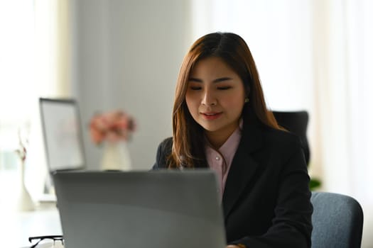 Beautiful asian woman entrepreneur working on investment and marketing projects at modern office.