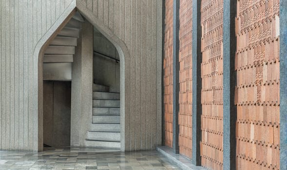 Bangkok,Thailand - May 28, 2023 - View of brick tiled wall and the stone arched entrance leads to the stone staircase. Architecture Exterior of the Stone arch and stone staircase in the background, Classic construction of the old stone stairs. Selective focus.