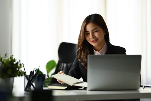 Beautiful asian woman entrepreneur working on investment and marketing projects at modern office.