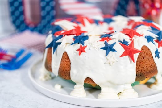 July 4th bundt cake covered with a vanilla glaze and decorated with chocolate stars on a white plate.