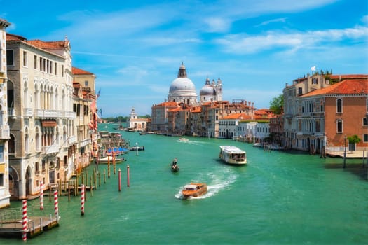 View of Venice Grand Canal with boats and Santa Maria della Salute church in the day from Ponte dell'Accademia bridge. Venice, Italy