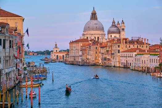 VENICE, ITLAY - JULY 19, 2019: View of Venice Grand Canal with boats and Santa Maria della Salute church on sunset from Ponte dell'Accademia bridge. Venice, Italy