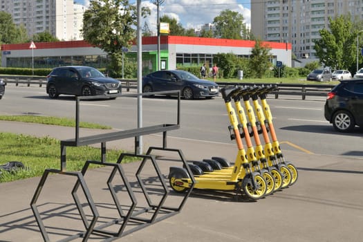 Moscow, Russia - July 21. 2023. Yandex go company electric scooters on the background of the road with cars in Zelenograd