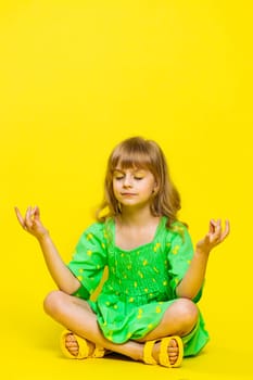 Keep calm down. Blonde child girl kid breathes deeply with mudra gesture, eyes closed, meditating with concentrated thoughts, peaceful mind, relaxing, taking a break, rest. Preteen children. Vertical