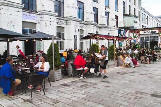 Saint Petersburg, Russia - July 29, 2023: People relax in an outdoor cafe. St. Petersburg street with people resting in a cafe