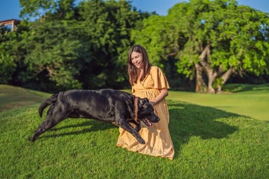 A serene and radiant pregnant woman after 40 and her dog, surrounded by nature's beauty in the park, cherishing the journey of motherhood with a glowing smile.