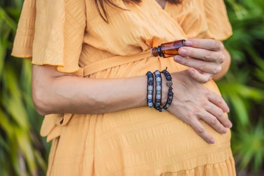 pregnant woman after 40 demonstrating the use of an aroma pendant, combining style and aromatherapy during her pregnancy journey.