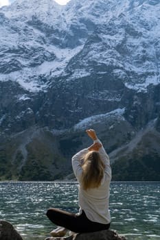 Young woman enjoying nature in Morskie Oko Snowy Mountain Hut in Polish Tatry mountains Zakopane Poland. Naturecore aesthetic beautiful green hills. Mental and physical wellbeing Travel outdoors tourist destination