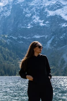 Young woman enjoying nature in Morskie Oko Snowy Mountain Hut in Polish Tatry mountains Zakopane Poland. Naturecore aesthetic beautiful green hills. Mental and physical wellbeing Travel outdoors tourist destination