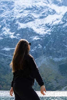 Young woman enjoying nature in Morskie Oko Snowy Mountain Hut in Polish Tatry mountains Zakopane Poland. Naturecore aesthetic beautiful green hills. Mental and physical wellbeing Travel outdoors tourist destination