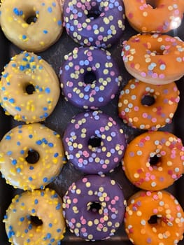 Flying Frosted sprinkled donuts. Set of multicolored doughnuts with sprinkles isolate on color background.