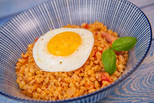 RECIPE FOR BLE WITH BACON, TOMATO AND SHALLOTS, SERVED WITH FRIED EGG. High quality photo