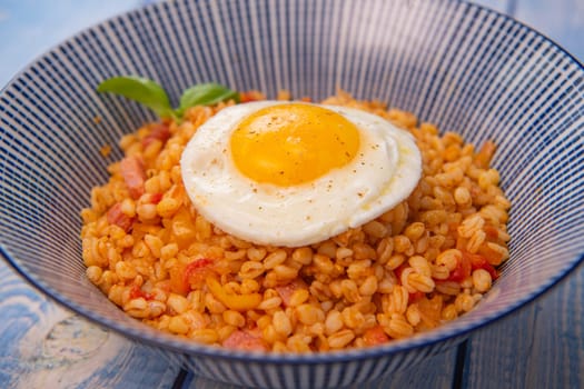 RECIPE FOR BLE WITH BACON, TOMATO AND SHALLOTS, SERVED WITH FRIED EGG. High quality photo