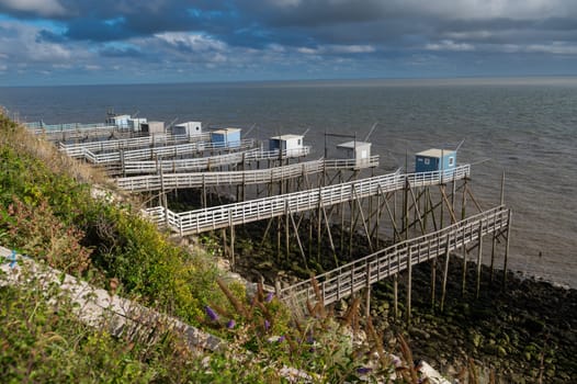Traditional fisherman's wooden hut at the bottom of the limestone cliff in the estuary of Gironde, Talmont-sur-Gironde, France. High quality photo