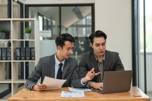 Asian business adviser meeting to analyze and discuss the situation on the financial report in the meeting room. Investment Consultant, Financial Consultant, Financial advisor and accounting concept.