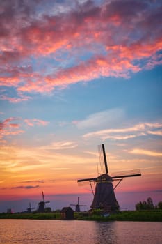 Netherlands rural lanscape with windmills at famous tourist site Kinderdijk in Holland on sunset with dramatic sky