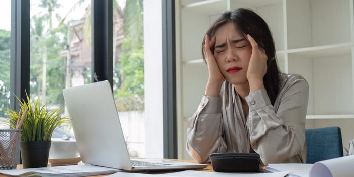 Asian business woman got stressed at work during in the office room, stressed face while working.