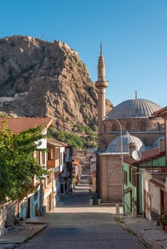 Traditional Turkish Ottoman houses in Afyonkarahisar Turkey. Afyon Castle on the rock and Mevlevihane Museum in front of it