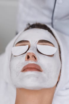 beautiful woman with mask on face at spa salon.