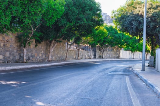 Rural empty asphalt road with sharp turn, asphalt road in the city with green trees. download photo