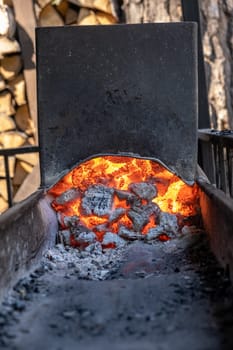 Burning coals in a metal grill for frying meat and vegetables. Cooking on a campfire.