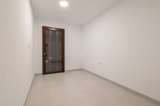 Empty bright room with a panoramic glass door leading to a balcony. The concept of renting housing in a new building or an apartment after renovation.