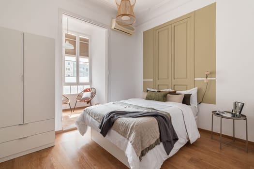 A luxurious bedroom with bright interiors, elegant furniture, and a warm hardwood floor. A spacious and inviting space perfect for architectural and home design concepts.