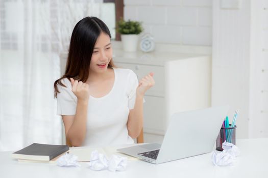 Young asian woman confident working at home with laptop computer and thinking idea for planning, freelance happy girl expression with excited and success using notebook thought, business concept.