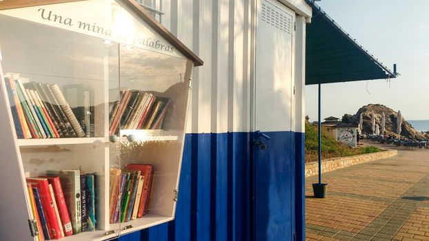 Portman, Cartagena, Spain- July 19, 2021: Street library available to the public on the beach of Portman village in summer