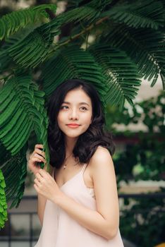 Young woman, against background of summer green leaves