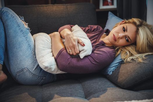 Shot of a an attractive young woman looking depressed and sadness while lying on the sofa at home.