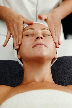 Shot of a beautiful mature woman enjoying face massage at the beauty salon.