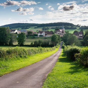 burgundy countryside village of french morvan with green grassy fields and forests under blue sky with clouds