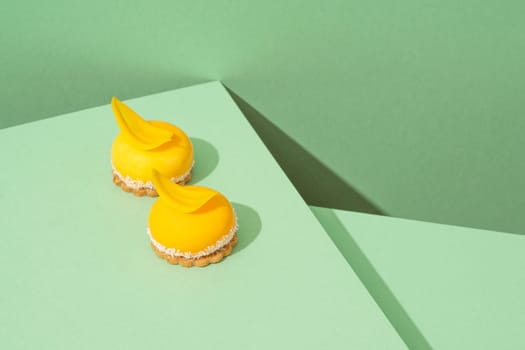 A tray of freshly baked yellow cupcakes with delicious white whipped icing on top and green background