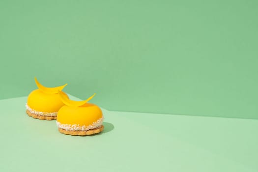 A tray of freshly baked yellow cupcakes with delicious white whipped icing on top and green background