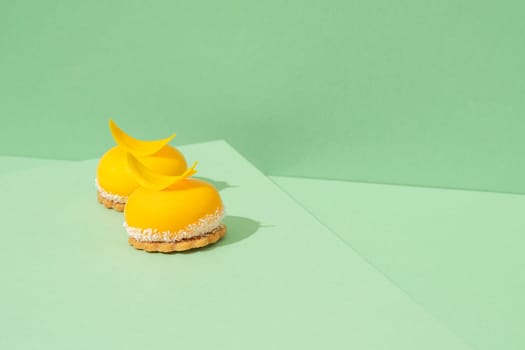 A tray of freshly baked yellow cupcakes with delicious white whipped icing on top and green background