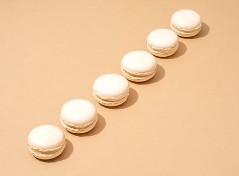 An image of white macaroons on a tan background with plenty of copy space for text or logo overlay
