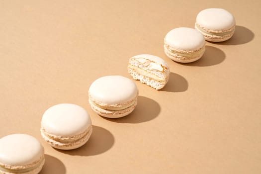 A still life image featuring six white macarons, arranged in a stack on top of each other