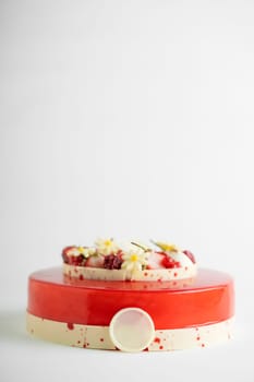 An appetizing cake displayed on a red and white striped cake stand, ready to be eaten
