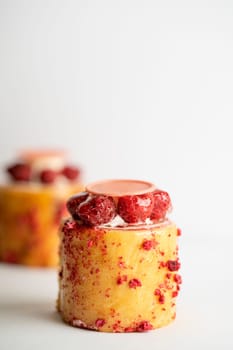 A delicious dessert of raspberry pudding topped with luscious cream and a sweet drizzle