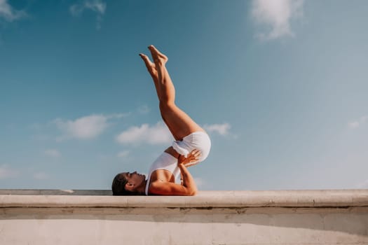 Fitness woman sea. Outdoor workout on yoga mat in park near to ocean beach. Female fitness pilates yoga routine concept. Healthy lifestyle. Happy fit woman exercising with rubber band in park.