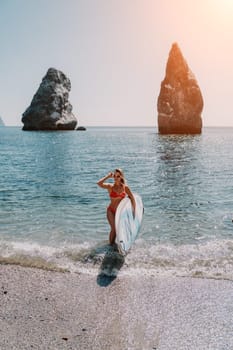 Close up shot of beautiful young caucasian woman with black hair and freckles looking at camera and smiling. Cute woman portrait in a pink bikini posing on a volcanic rock high above the sea