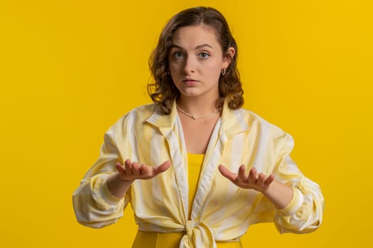Hey you, be careful, slowly. Young woman warning with admonishing finger gesture, saying no, be careful, scolding and giving advice to avoid danger disapproval sign. Girl isolated on yellow background